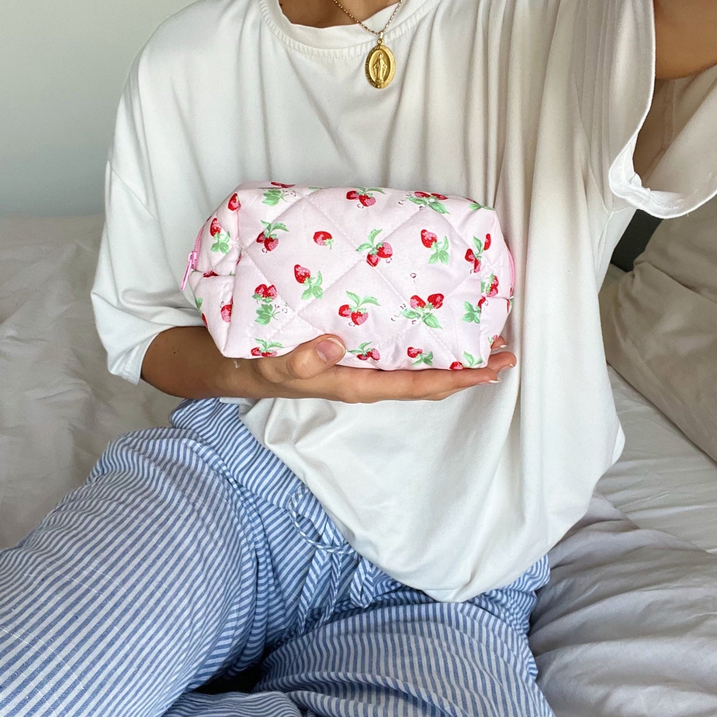 Pink makeup bag with a strawberry design.