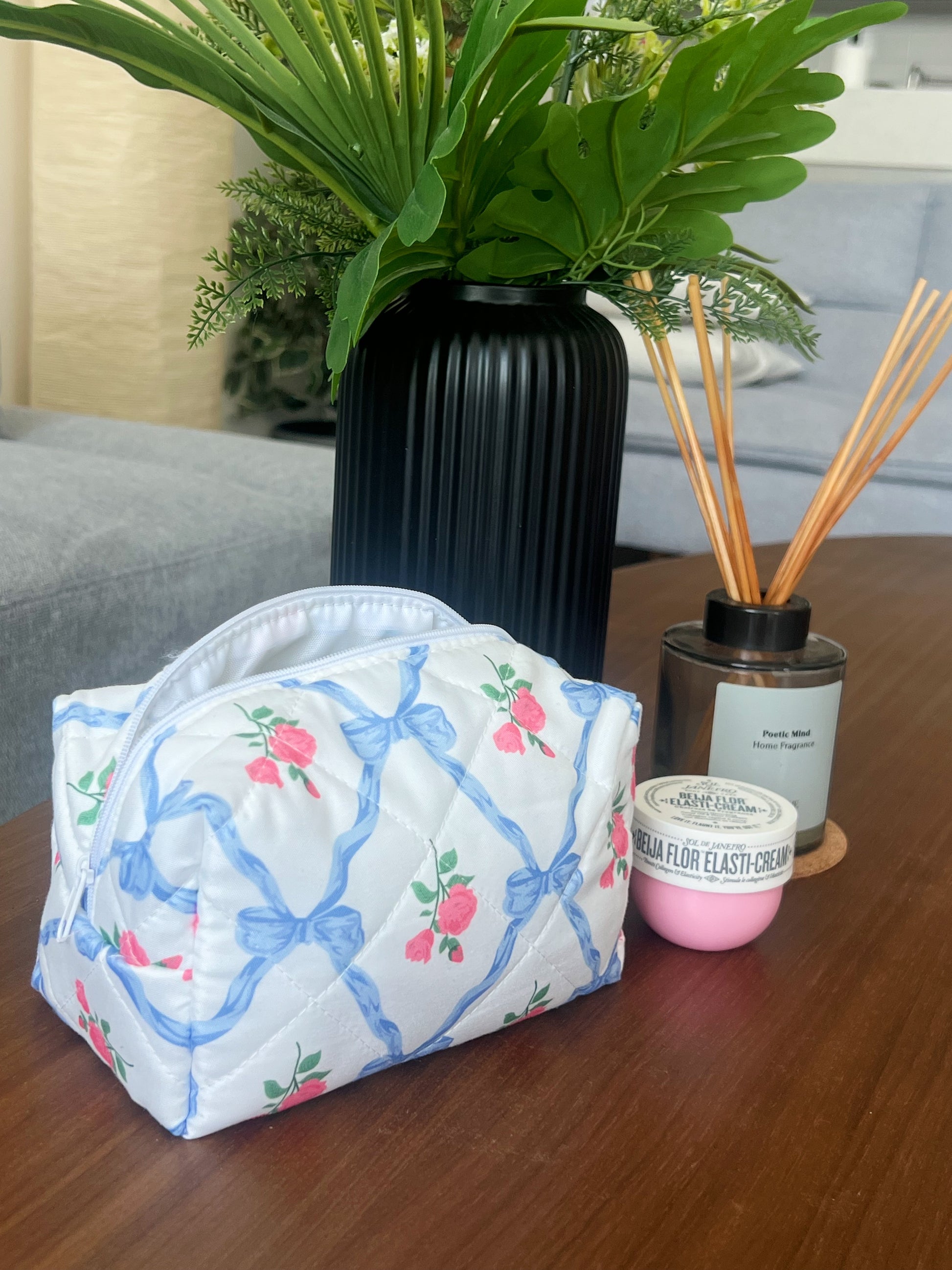 Blue beauty pouch with bows and roses. Makeup bag for makeup. skincare, travel and beauty essentials.