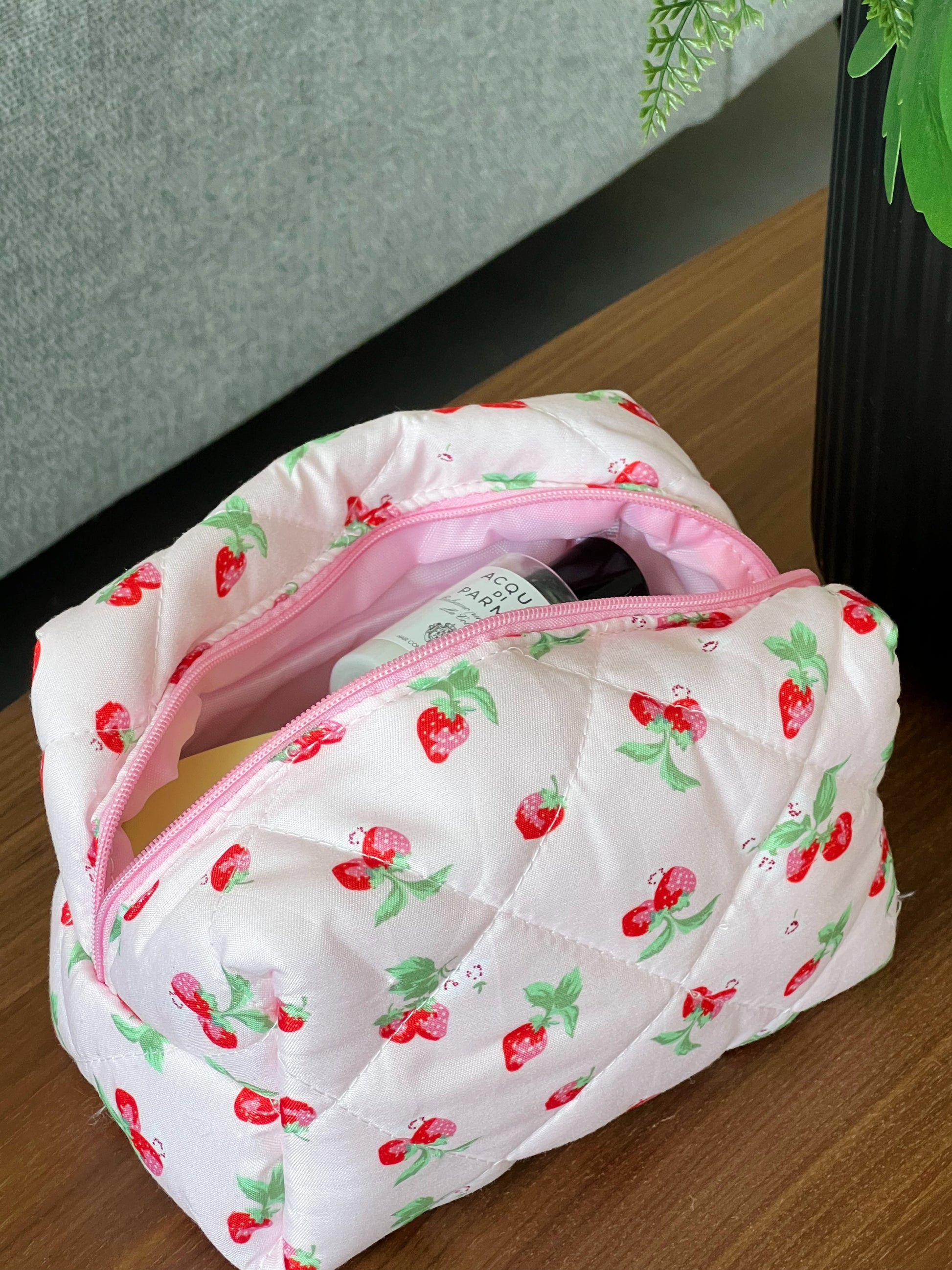 Pink makeup bag with a strawberry design. Perfect for travel, makeup, skincare and more.