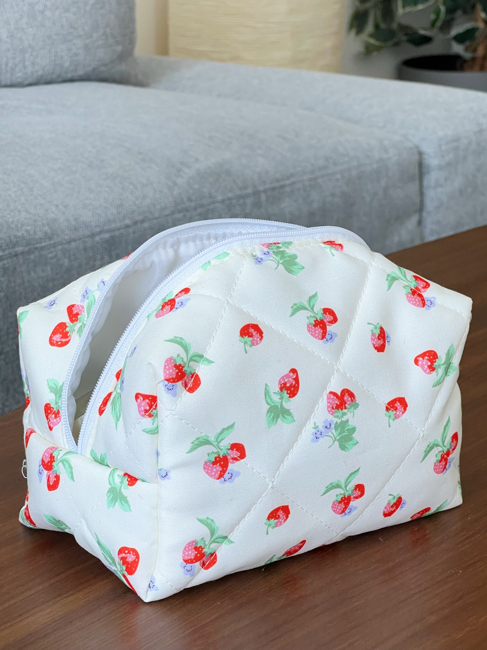 Yellow travel bag with strawberry designs. Perfect for travel, skincare and makeup.